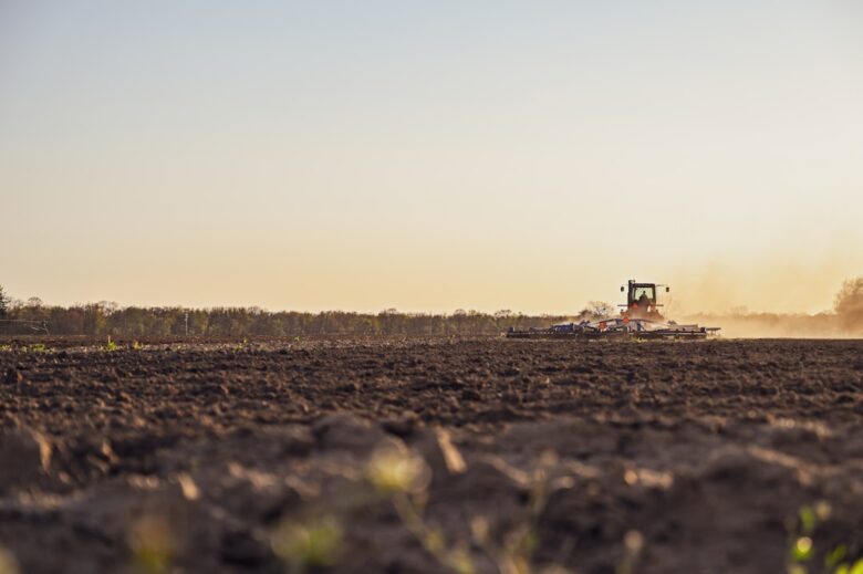 Produtor rural semeando em campo aberto